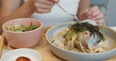 Kadın restoranda makarna yiyor.