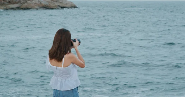 Woman take photo on camera for the sea view