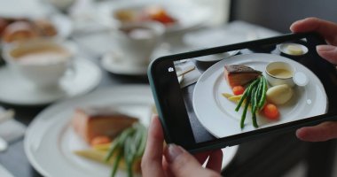Kadın çanak antenlerin fotoğrafını çekmek için cep telefonu kullanıyor.