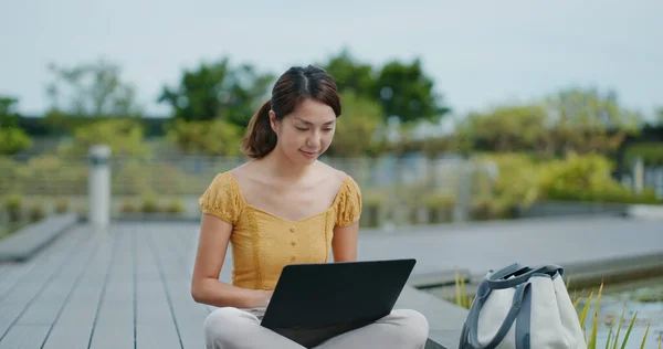 Woman work on laptop computer at park