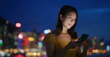 Geceleri kadın cep telefonu kullanıyor.