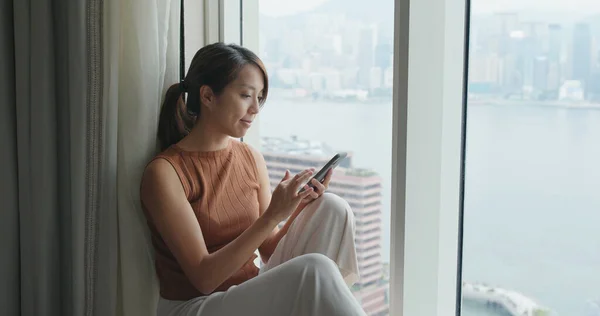 Жінка Використовує Мобільний Телефон Сидить Біля Вікна — стокове фото