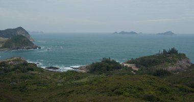 Deniz dalgaları adada kayalara çarpıyor.