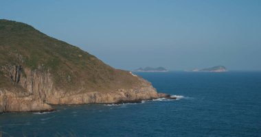 Deniz dalgaları adada kayalara çarpıyor.