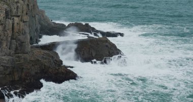 Okyanus dalgaları adada kayalara çarpıyor.