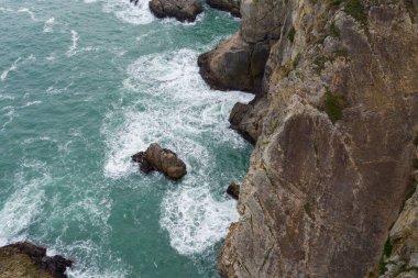 Okyanus dalgaları kayalara çarpar.