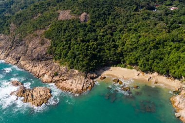 Okyanus dalgası adanın kayalıklarına çarpıyor.