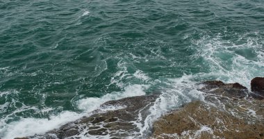 Okyanus dalgaları kayalara çarpar.