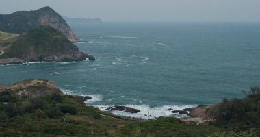 Deniz dalgaları adada kayalara çarpıyor.