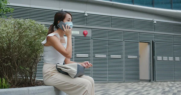 Woman wear face mask and talk on cellphone at outdoor