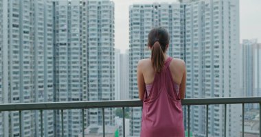 Kadın şehir manzarasına tepeden bakıyor.