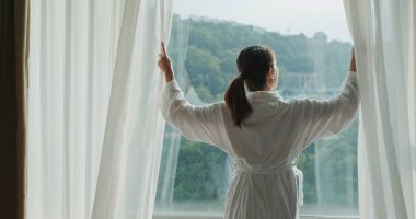 Sabah perdeyi açan kadın.