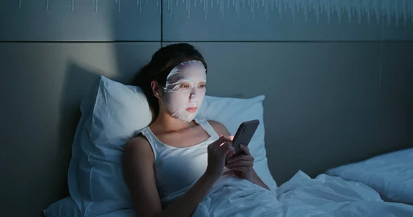 Vrouw Gebruik Van Papieren Masker Gebruik Van Mobiele Telefoon Bed — Stockfoto