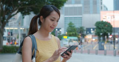 Akşamları dışarıda akıllı telefon kullanan bir kadın.