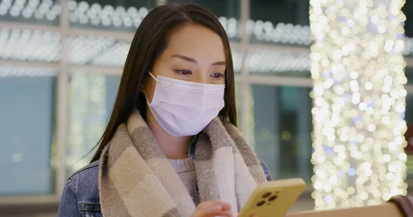 Woman wear face mask and use of smart phone at night