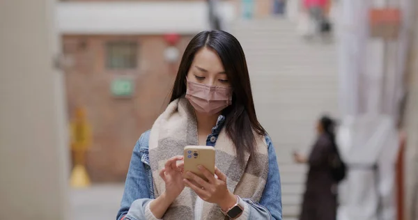 Woman wear face mask and use of smart phone