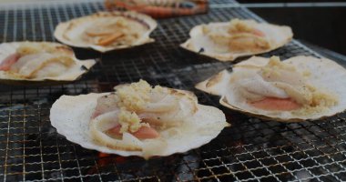 Barbekü ağında taze deniz tarağı