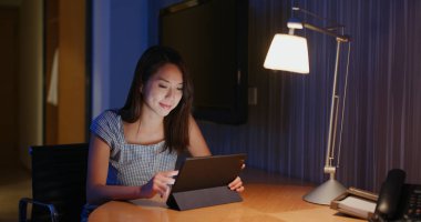 Kadın evde tablet bilgisayarda çalışıyor.