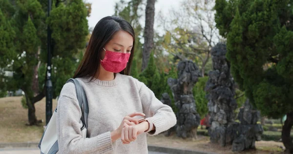 女性は屋外で顔マスクを着用し スマートウォッチの使用 — ストック写真