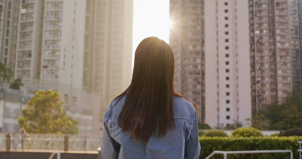 女人看着有阳光的大楼 — 图库照片