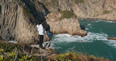 Kadınlar dağdan deniz manzarasının tadını çıkarırlar.