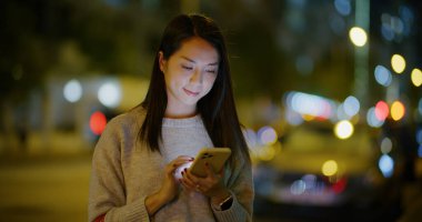 Kadınlar açık havada akıllı telefon kullanır.