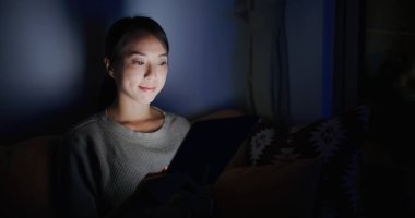 Kadın akşamları evde tablet bilgisayar kullanıyor