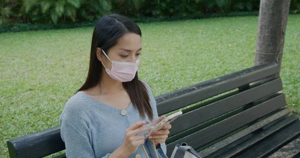 Donna Indossare Maschera Facciale Uso Del Telefono Cellulare Sedersi Parco — Foto Stock
