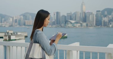 Dışarıdaki tablet bilgisayara dijital kalem kullanan kadın.