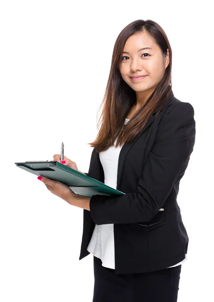 Asian businesswoman write on clipboard — Stock Photo, Image