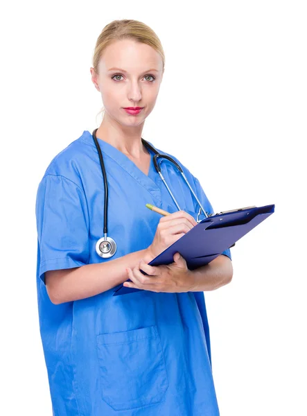 Vrouwelijke arts schrijven op Klembord — Stockfoto
