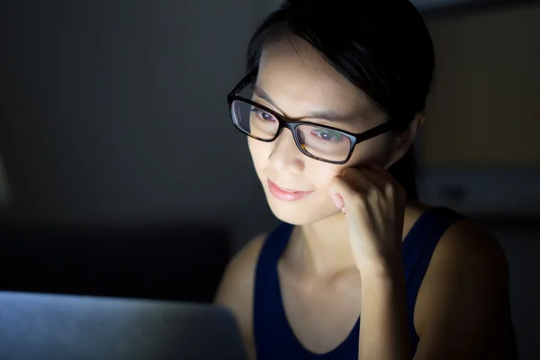 Женщина смотрит на компьютер ночью — стоковое фото