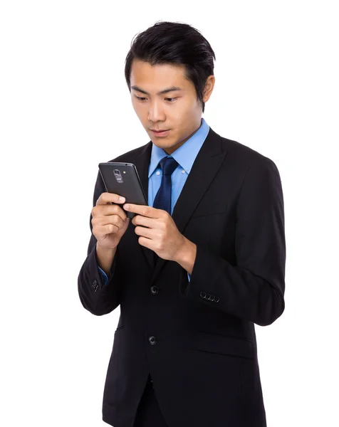 Бизнесмен смотрит на мобильный телефон — стоковое фото