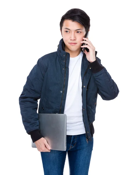 Man with notebook talking on cellphone — Stock Photo, Image