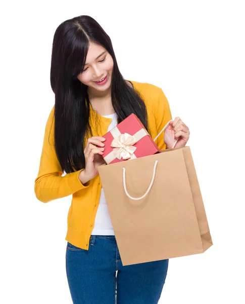 Kvinnan tar presentförpackning från shopping väska — Stockfoto