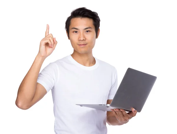 Young man with laptop pointing — Stock Photo, Image