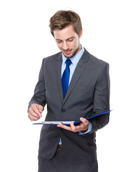 Businessman writes on clipboard Stock Picture