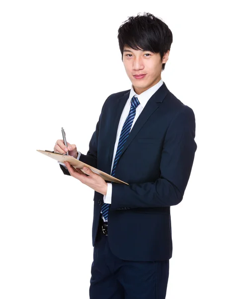 Businessman writes on clipboard — Stock Photo, Image