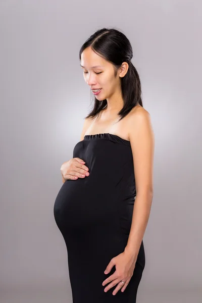 Schwangere Mutter schaut auf ihren Bauch — Stockfoto