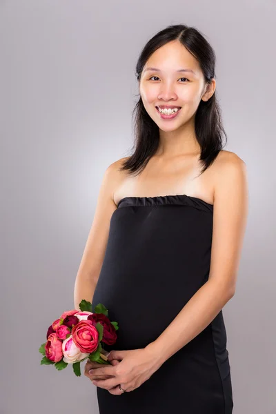アジアの妊娠中の母親が花を持つ — ストック写真