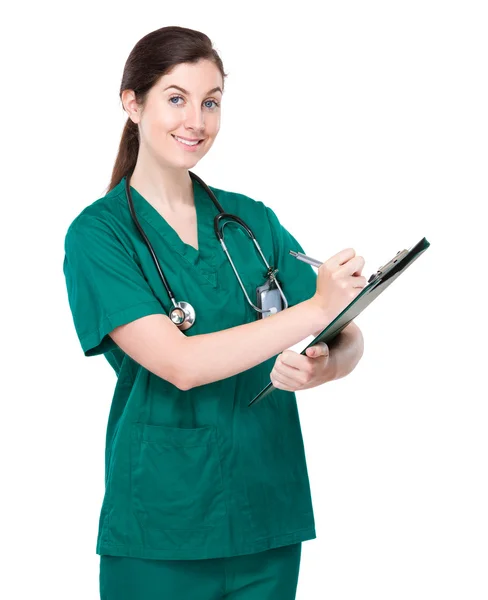 Female doctor writes on clipboard — Stock Photo, Image
