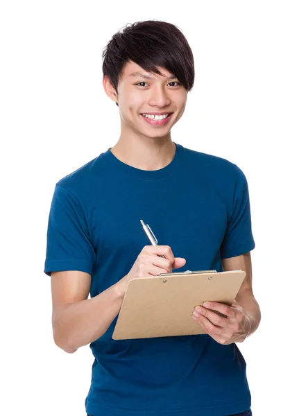 Aziatisch mens schrijft op Klembord — Stockfoto