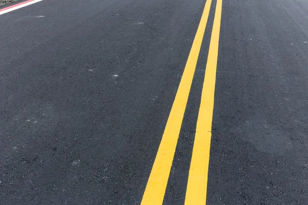 Yellow stripes on asphalt road — Stock Photo, Image