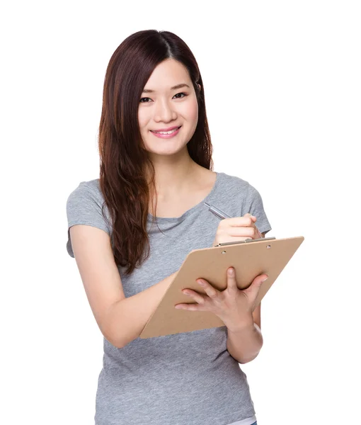 Woman writes on clipboard — Stock Photo, Image