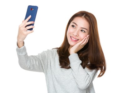 Kadın akıllı telefonuyla selfie çekiyor.