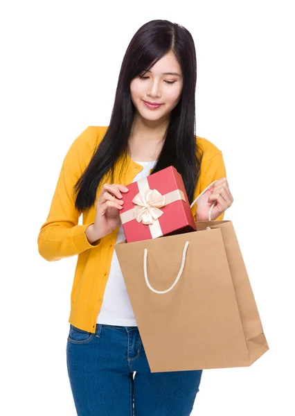 Женщина берет подарочную коробку из сумки — стоковое фото