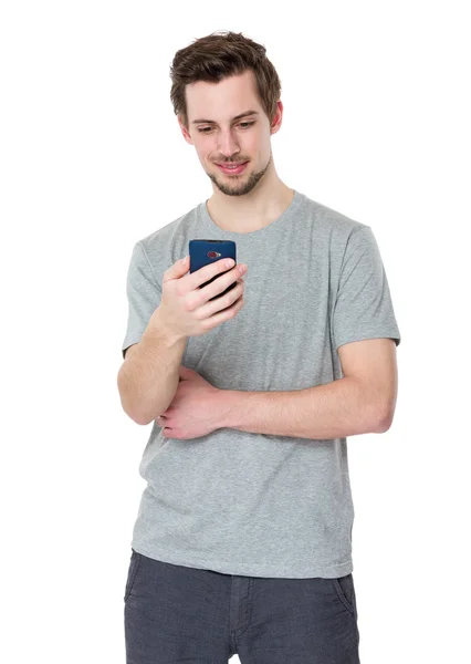 Lächelnder Mann schaut aufs Handy — Stockfoto