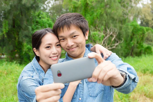 Asiatiska par med selfie i park — Stockfoto