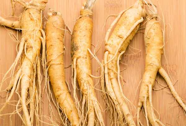 Radici di ginseng su tavolo di legno — Foto Stock