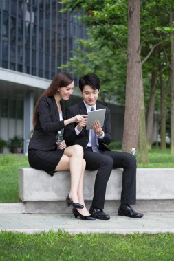 Dijital tablet kullanan iş adamı ve işkadını